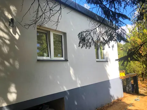 A ház oldalsó homlokzata a kert fáival